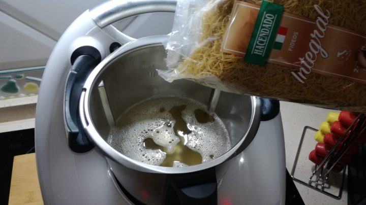 Echar fideos de sopa en el vaso.