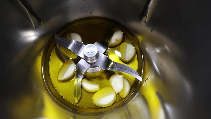 Echamos el aceite y el ajo en el vaso para picar