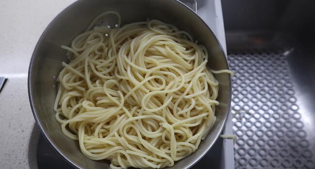 Escurrimos los espaguetis y lo rehogamos en la sartén con un ajo frito