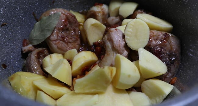 Echar las patatas junto a la carne para cocinar
