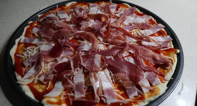Poner los ingredientes encima de la masa de la pizza