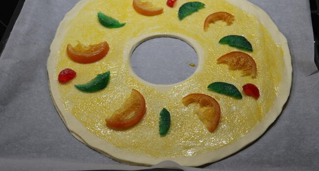 Pincelamos la parte superior, le colocamos las fruta escarchada y metemos en el horno